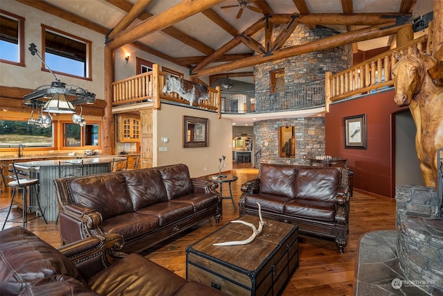 living room featuring dark hardwood / wood-style flooring, ceiling fan, beam ceiling, and high vaulted ceiling