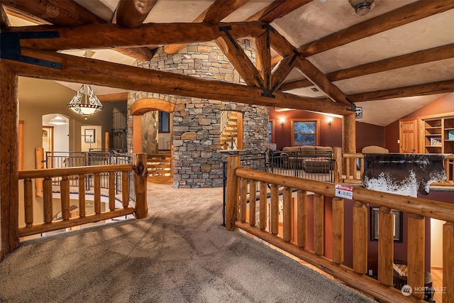 interior space with dark carpet and vaulted ceiling with beams