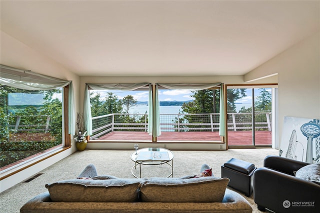 living room with a water view and carpet floors