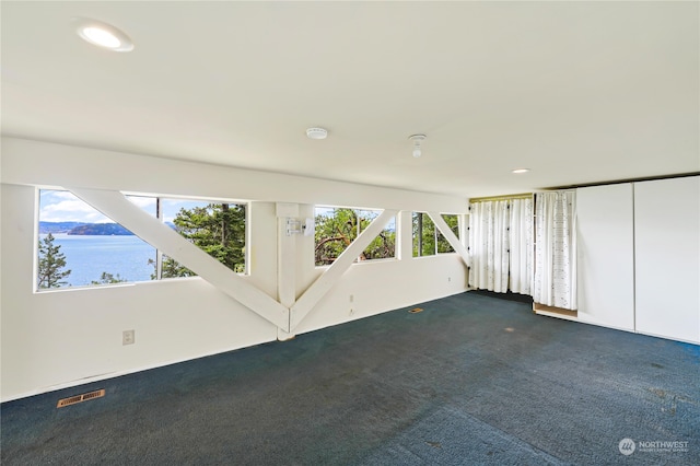 carpeted spare room with a water view