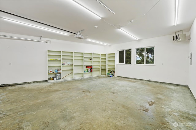 garage with a garage door opener and a wall mounted AC