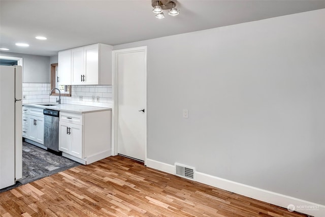 kitchen with white cabinets, dishwasher, white fridge, and light wood-type flooring