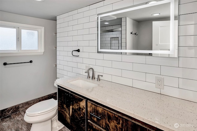 bathroom featuring vanity, toilet, and tile walls