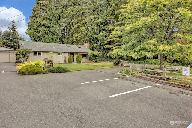 view of parking / parking lot featuring a yard