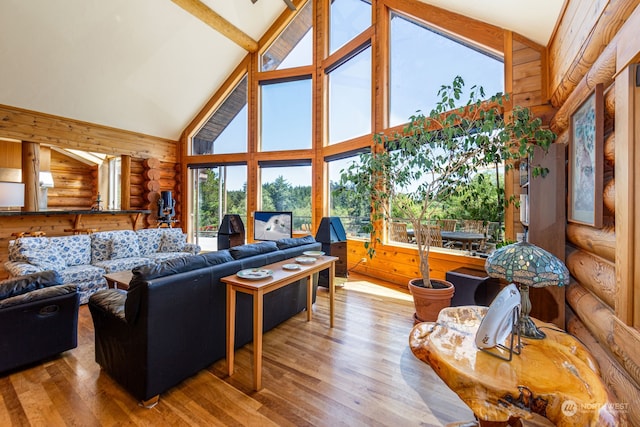 living room featuring high vaulted ceiling, wood-type flooring, and log walls