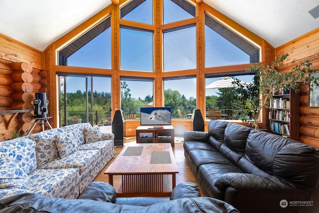 living room with rustic walls, high vaulted ceiling, and hardwood / wood-style flooring