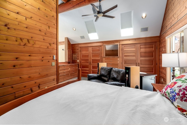 bedroom featuring wood walls, lofted ceiling, multiple windows, and ceiling fan