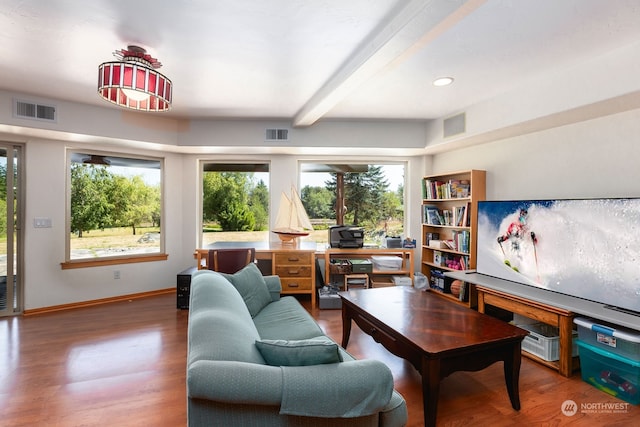 living room with plenty of natural light, beam ceiling, and wood-type flooring