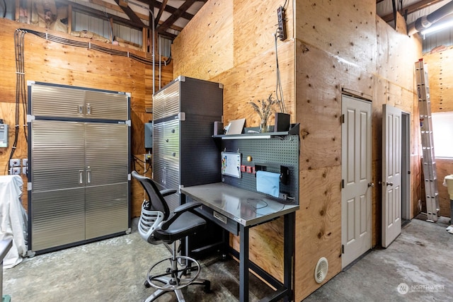 office space with concrete floors and a towering ceiling