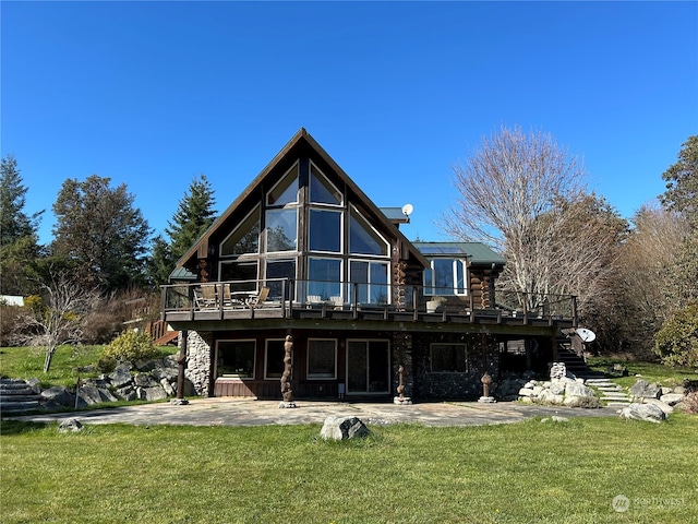 back of property featuring a lawn, a balcony, and a patio area