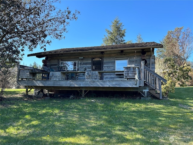 rear view of house featuring a deck and a yard