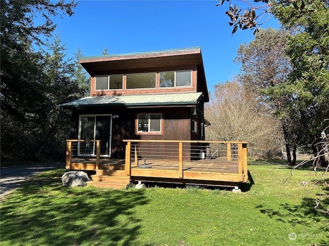 rear view of property featuring a wooden deck and a lawn