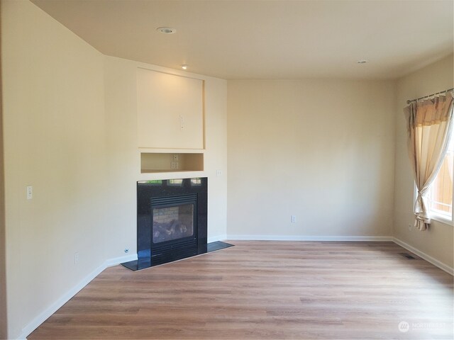 unfurnished living room with light hardwood / wood-style flooring