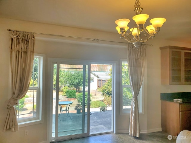 entryway with an inviting chandelier and light tile flooring