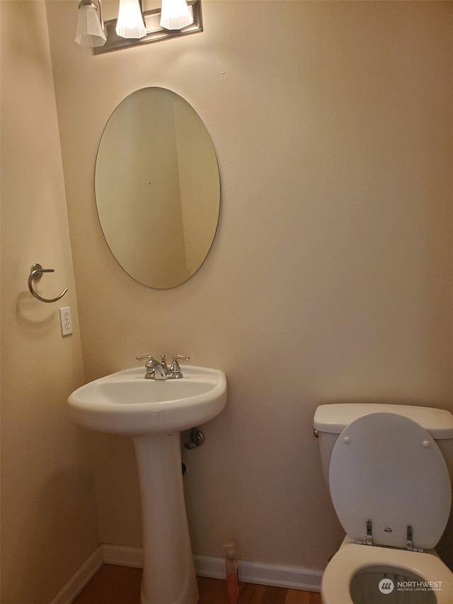 bathroom with toilet and hardwood / wood-style flooring