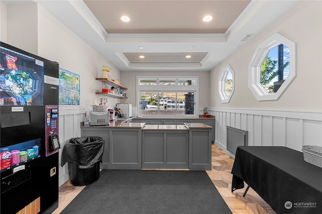 interior space with gray cabinetry, black fridge, a raised ceiling, and plenty of natural light