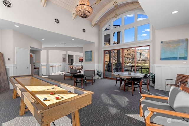 recreation room with high vaulted ceiling, wooden ceiling, a notable chandelier, and dark colored carpet