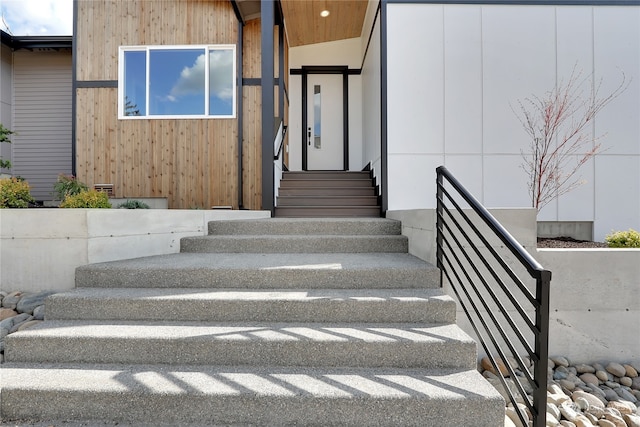 stairway featuring lofted ceiling and wood walls