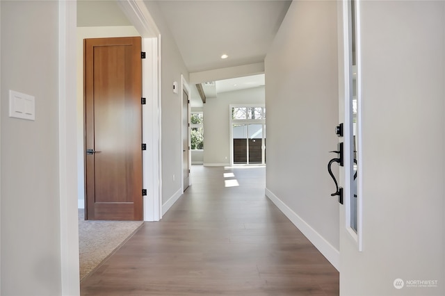 corridor with lofted ceiling and light wood-type flooring