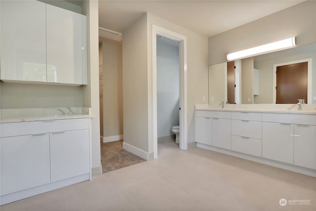 bathroom with tile floors, toilet, and vanity