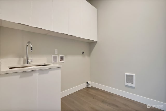 laundry room featuring sink, hookup for a washing machine, dark hardwood / wood-style flooring, electric dryer hookup, and cabinets