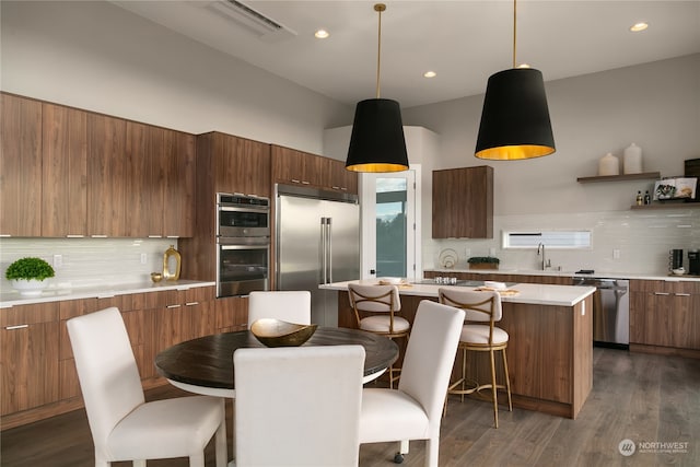 kitchen featuring stainless steel appliances, backsplash, and dark hardwood / wood-style floors