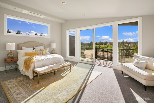 bedroom with multiple windows, dark carpet, and access to exterior