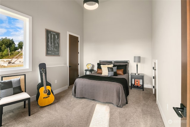 carpeted bedroom with a high ceiling