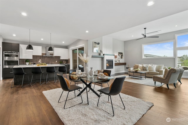 dining space with hardwood / wood-style floors, ceiling fan, and vaulted ceiling