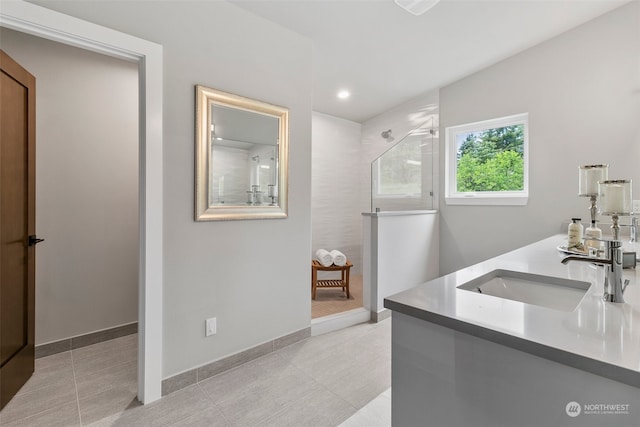 bathroom featuring tiled shower and vanity