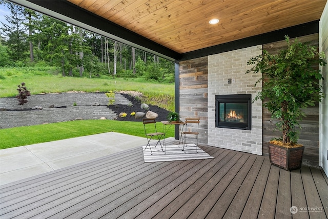 wooden deck with a yard and a patio