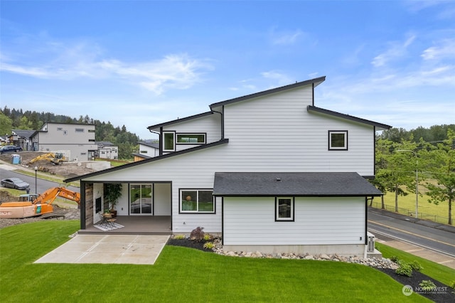 rear view of property featuring a lawn and a patio