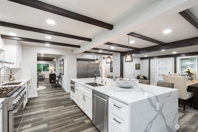 kitchen with high end appliances, decorative light fixtures, dark hardwood / wood-style floors, and light stone counters