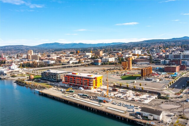 drone / aerial view featuring a city view and a water and mountain view