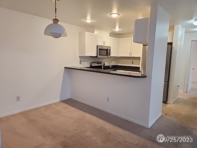 kitchen with decorative light fixtures, white cabinetry, sink, stainless steel appliances, and light carpet