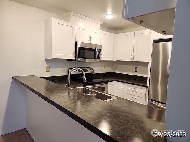 kitchen with appliances with stainless steel finishes, sink, and white cabinets