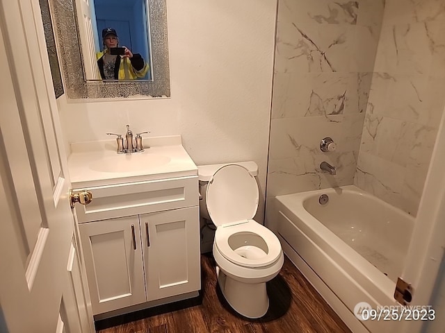 full bathroom with tiled shower / bath combo, toilet, vanity, and hardwood / wood-style flooring