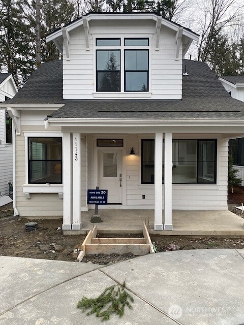 bungalow-style home with covered porch and a shingled roof