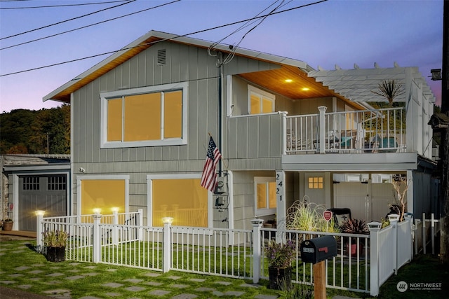 view of front of property with a balcony and a lawn