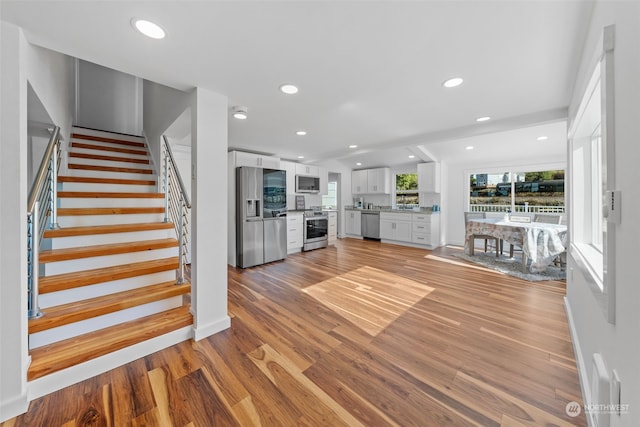 unfurnished living room with lofted ceiling and light hardwood / wood-style floors