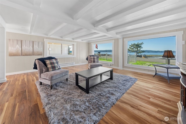 living room with a baseboard heating unit, light wood-type flooring, and beamed ceiling