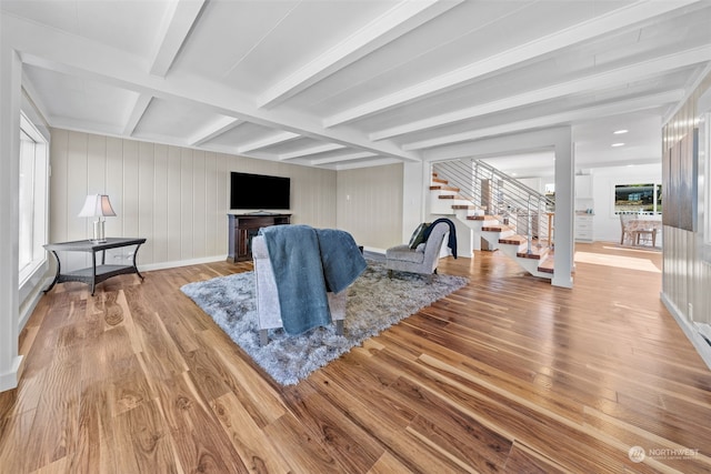 living room with light hardwood / wood-style floors and beamed ceiling