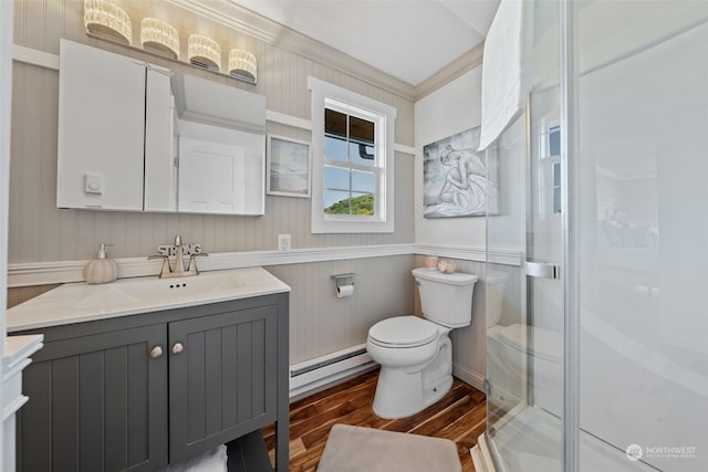 bathroom featuring toilet, ornamental molding, a baseboard heating unit, vanity, and hardwood / wood-style flooring