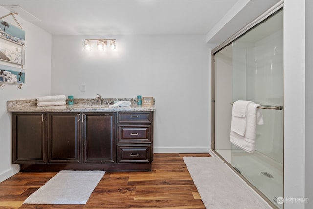 bathroom with an enclosed shower, vanity, and hardwood / wood-style flooring