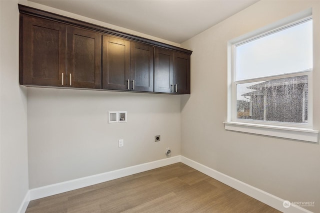 laundry room with electric dryer hookup, cabinets, hookup for a washing machine, and light hardwood / wood-style flooring