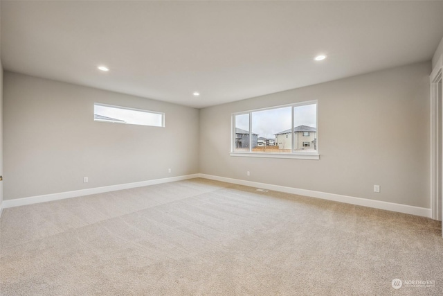 unfurnished room featuring light colored carpet and a healthy amount of sunlight