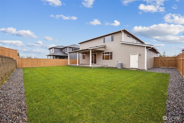 back of property with central AC unit, a patio area, and a yard