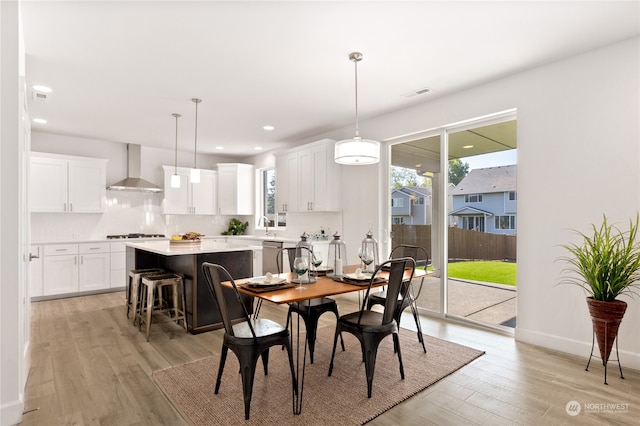 dining area with light hardwood / wood-style floors, sink, and a wealth of natural light