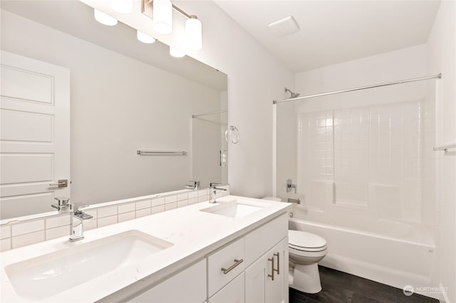 full bathroom featuring hardwood / wood-style floors, vanity, toilet, tasteful backsplash, and shower / bathtub combination