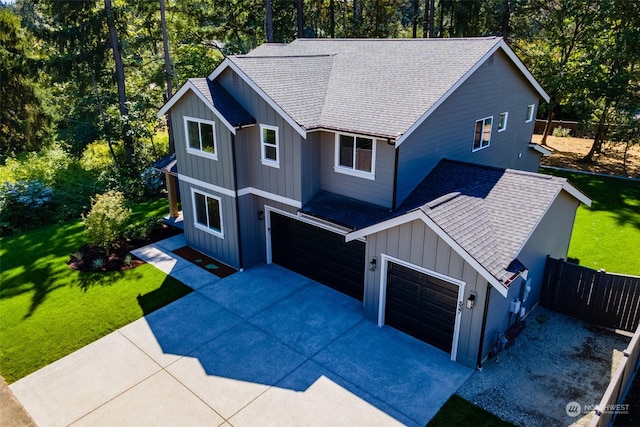 view of front of home featuring a shingled roof, board and batten siding, fence, a garage, and driveway